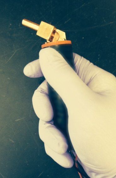 The handheld Peltier focal thermal stimulator David built, held in a gloved hand